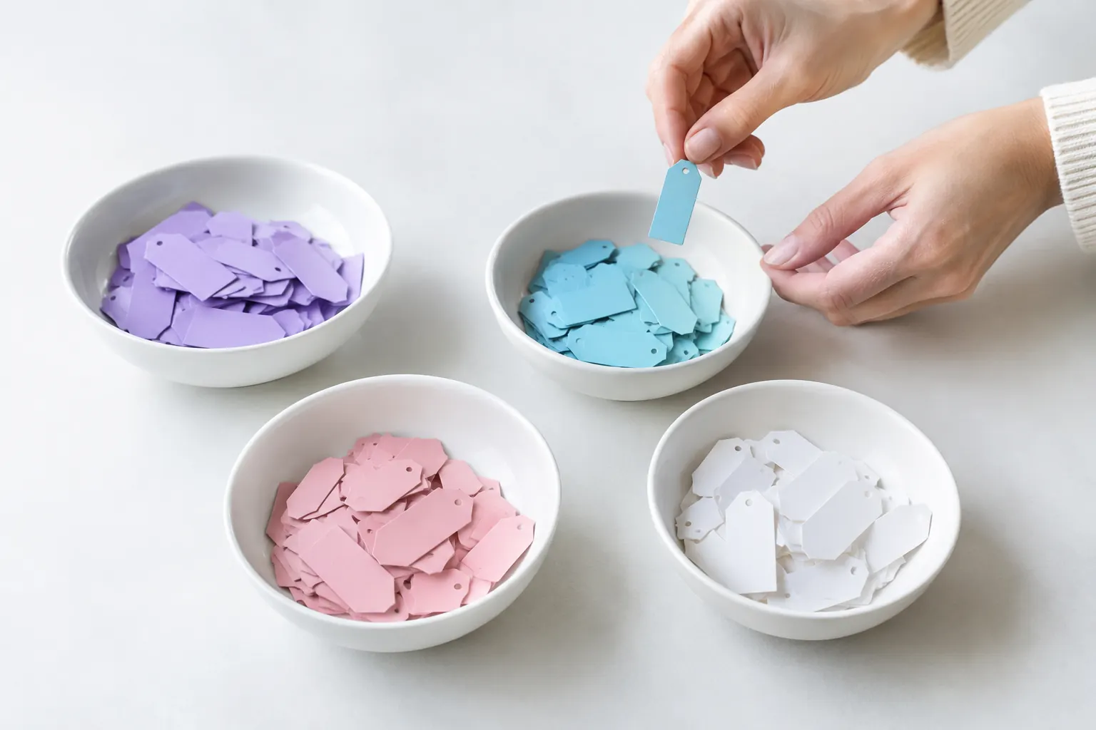 Étiquettes colorées triées dans quatre bols blancs, comme des mots-clés classés par intention de recherche avec l’IA